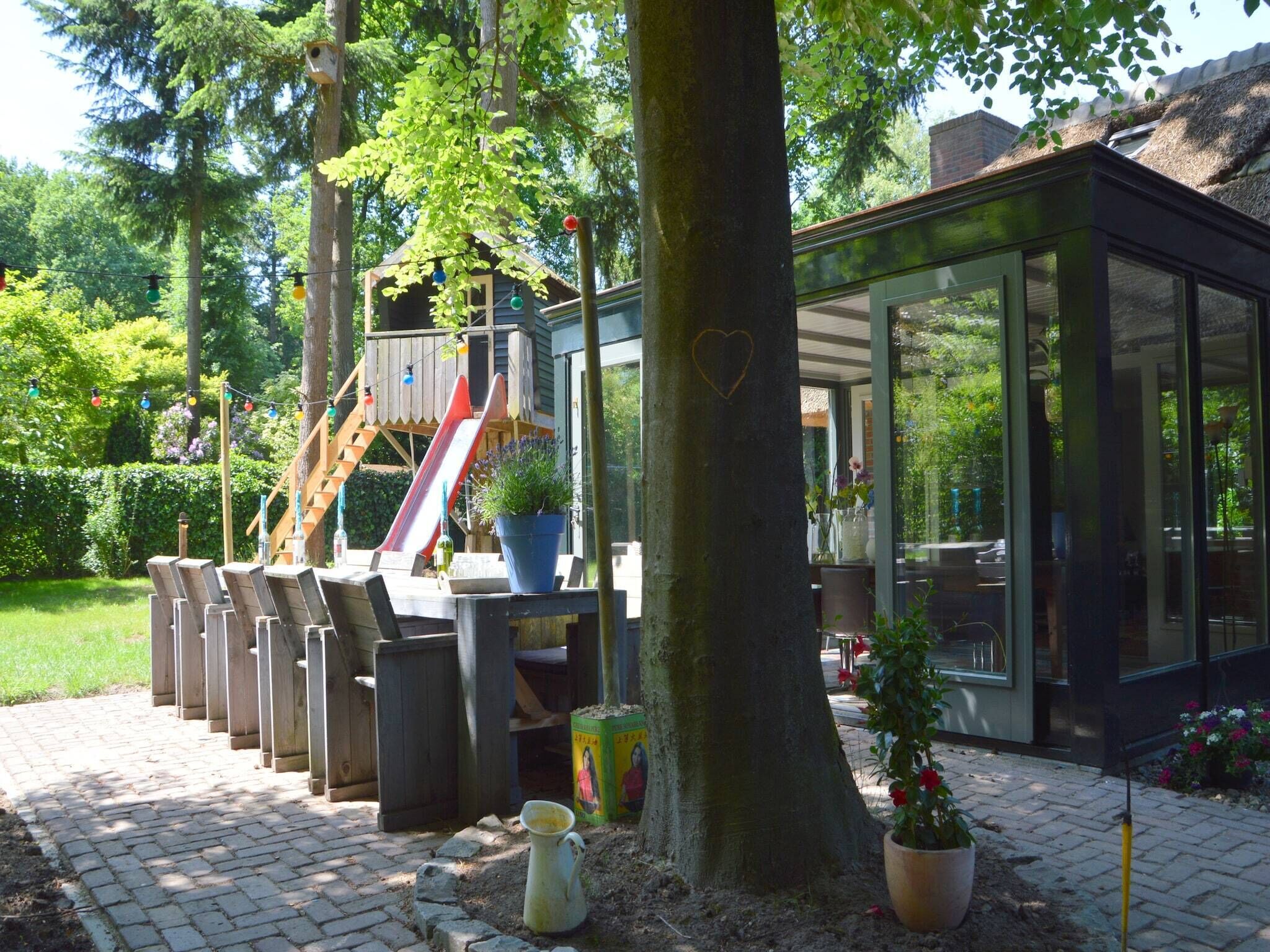 A patio area with a play structure, seating, and a glass-enclosed building.