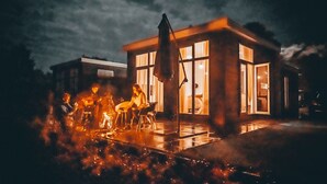 Ein modernes Haus mit großen Fenstern und einer Terrassenfläche.