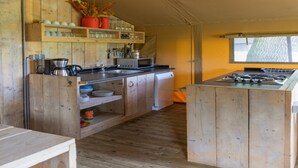 A compact kitchen with wooden cabinets, a sink, a stove, and a window providing natural light.
