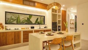 Una cocina moderna con armarios de madera, una isla grande con asientos y una lámpara colgante.