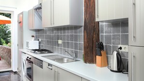 Une cuisine moderne dotée d’appareils électroménagers en acier inoxydable, d’un dosseret carrelé et d’éléments décoratifs en bois.