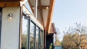 Een gebouw met grote ramen, een bord waarop 'Villa bianco' staat en een houten dak.