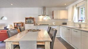 Eine moderne Küche mit weißen Schränken, einem Holztisch und einem eingebauten Herd.