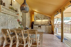 Un interior rústico de madera con comedor, cocina y terraza de madera.