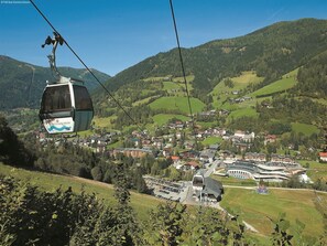 Sistema de teleférico con vistas a un pueblo situado en un valle rodeado de montañas.