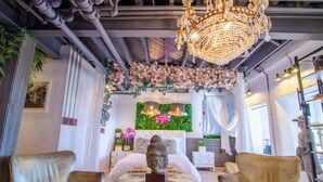 Une chambre à coucher luxueuse, dotée d’un grand lit, d’un lustre et de décorations florales.