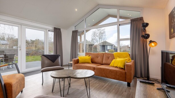 Een moderne woonkamer met een bank, fauteuils en een salontafel.