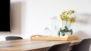 Ein Holztablett mit Glasflaschen und einer Topfpflanze auf einem Tisch.
