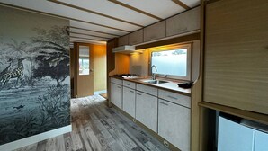 Une cuisine moderne avec des meubles en bois, une cuisinière encastrée et une fenêtre donnant sur un paysage pittoresque.