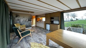 Un intérieur moderne comprenant un coin repas, une cuisine et une vue sur l’extérieur.