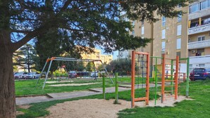 A playground with swings and climbing structures, surrounded by a grassy area and a tree. - Apartment Zora - 
Charming 2-bedroom apartment with AC, WiFi in amazing Pula (Pula)