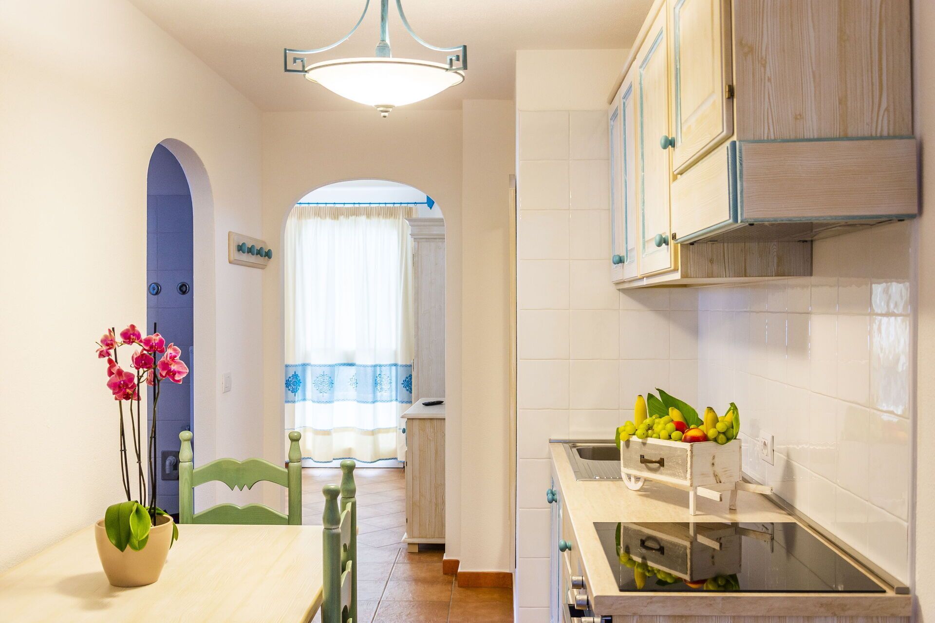 A kitchen with white cabinets, a wooden countertop, and a fruit basket.