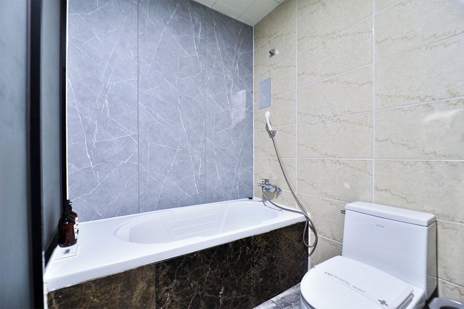 A bathroom with a white bathtub, a toilet, and a shower.