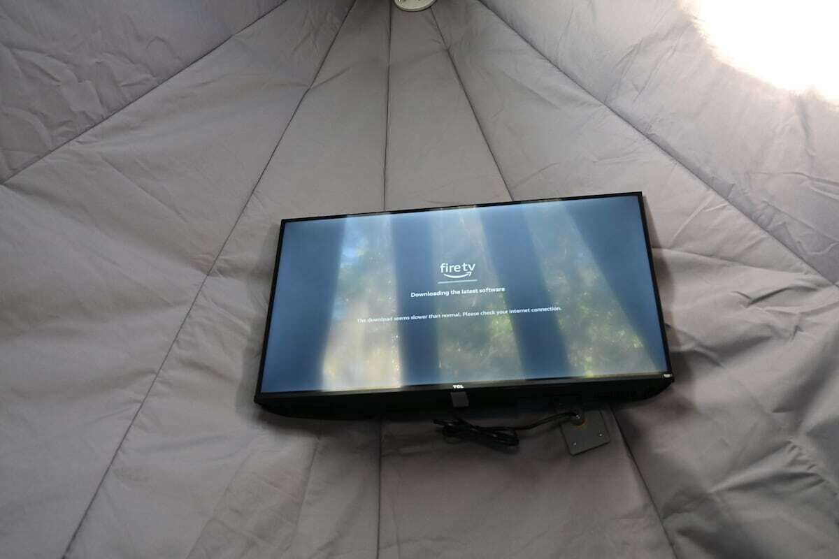A flat-screen TV on a bed with a firetv logo, indicating it is a streaming device.