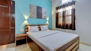 A neatly arranged bedroom with a wooden bed, bedside tables, and a wall-mounted light fixture.