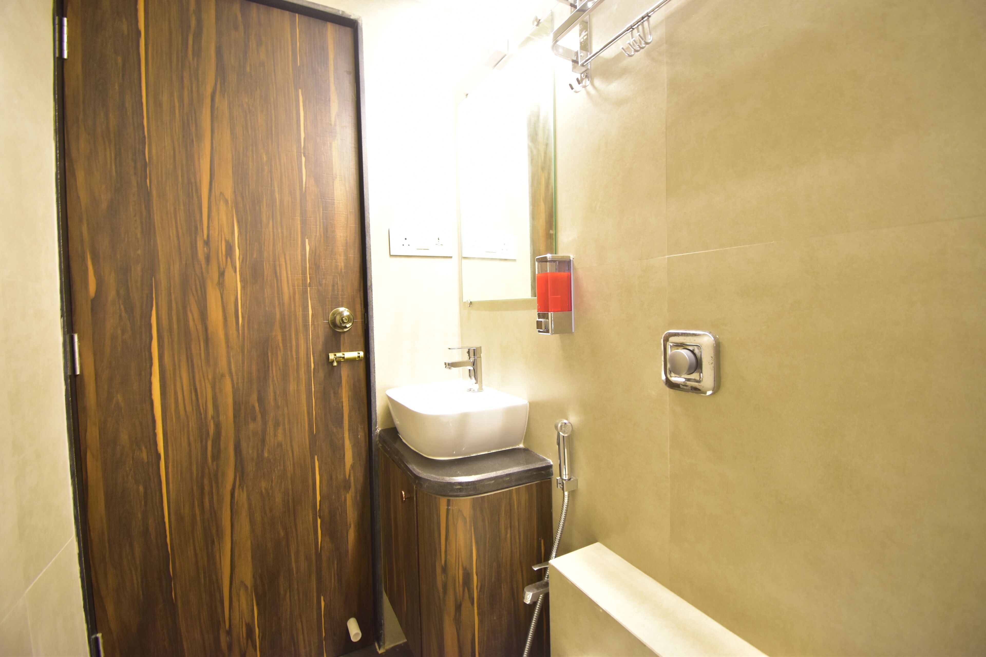 Un baño con puerta de madera, un lavabo y una ducha.