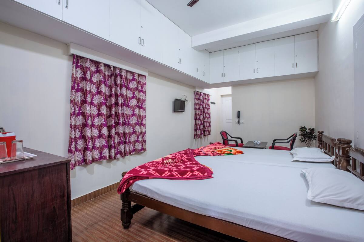 A bedroom with a bed, a desk, a chair, and a wardrobe.