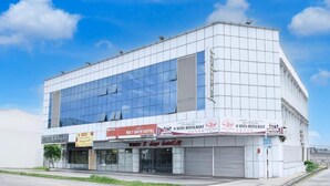 Un edificio moderno con fachada de vidrio, un letrero que dice 'KB 7 DAYS HOTEL' y otro letrero que indica 'H SEVEN RESTAURANT'.