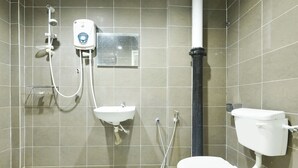 Un baño con inodoro, lavamanos y ducha.