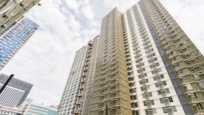 A high-rise building with multiple floors, large windows, and balconies.