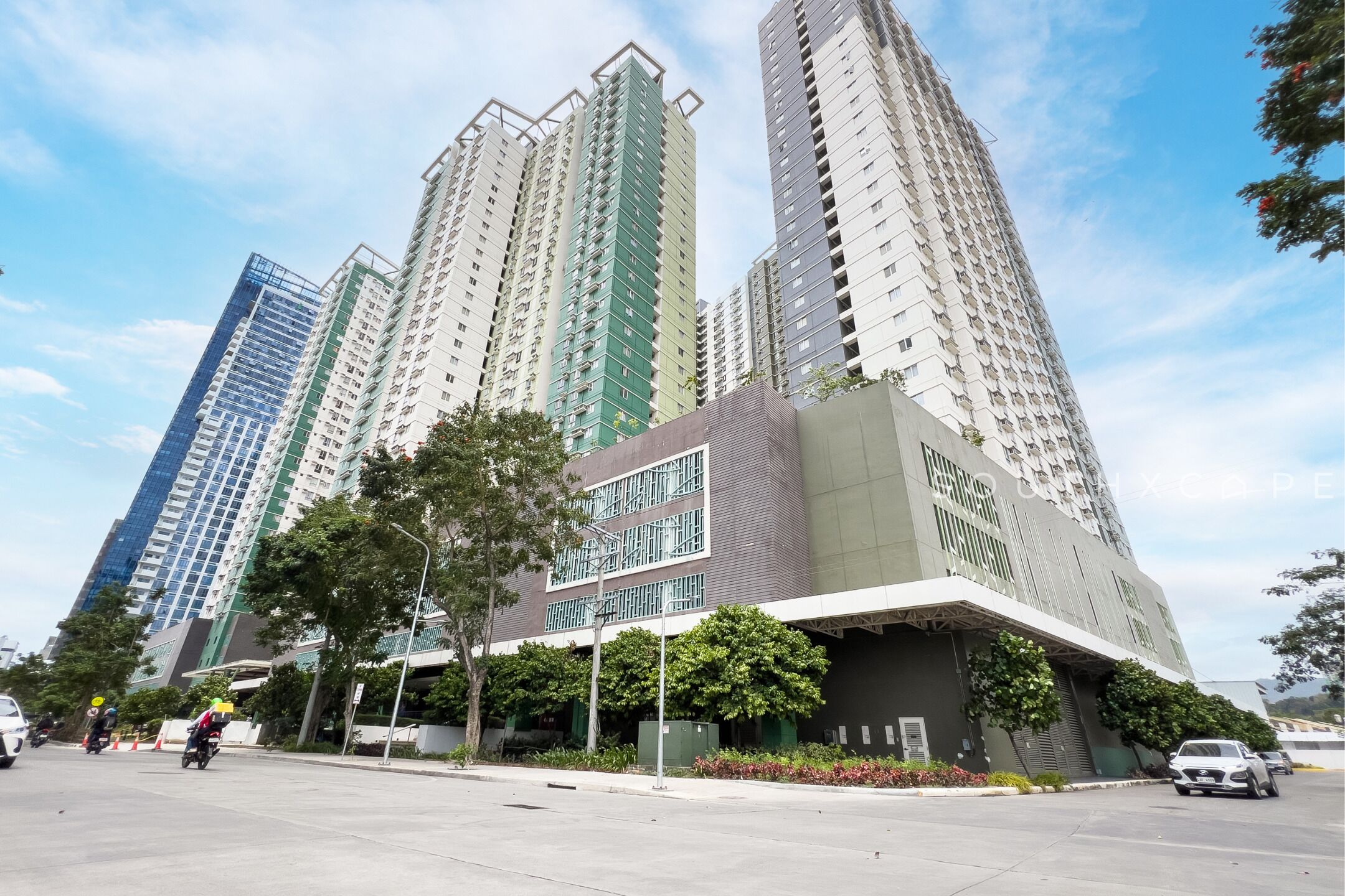 A multi-story residential building with a modern design, featuring balconies and large windows.