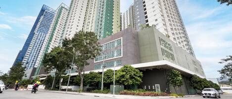 A multi-story residential building with a modern design, featuring balconies and large windows.