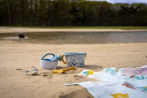 A beach scene with a beach umbrella, a beach chair, and a beach towel.