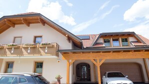 A two-story house with a balcony, a garage, and a solar panel on the roof. - Cosy apartment in Arnoldstein (Arnoldstein)