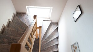 A staircase with wooden handrails and dark patterned steps. - Cosy apartment in Arnoldstein (Arnoldstein)