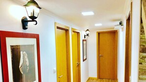 A hallway with wooden doors, a framed picture on the wall, and a light fixture. - Room-7lisbon Downtown Private Bedroom Wi (Lisbon)