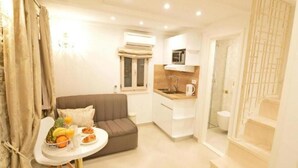 A compact living space with a kitchenette, a dining area with breakfast, and a staircase. - Villa madonna della Strada A5 (Dubrovnik)