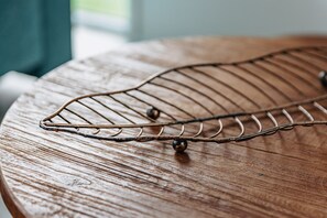 A metal wire rack with spherical weights on a round wooden table.