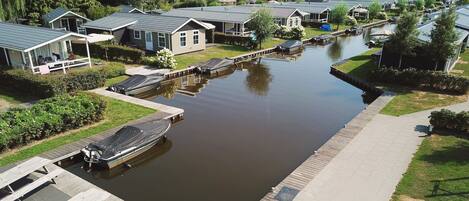 Zona residencial junto a un canal, con casas, un muelle y un bote.
