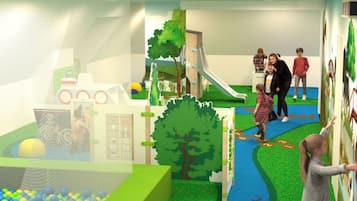 A children's play area with a slide, ball pit, and interactive wall.