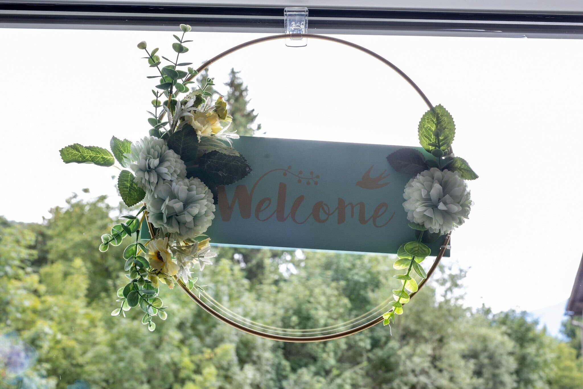 A 'Welcome' sign with a floral wreath.
