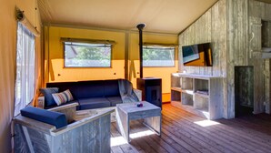 A cozy room with a sofa, a small table, and a TV mounted on a wooden wall.