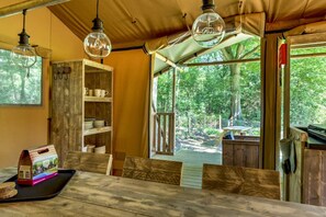 Un comedor rústico de madera con una mesa, sillas y lámparas colgantes.