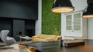 Un salon moderne avec un mur foncé, un mur vert et un meuble blanc.