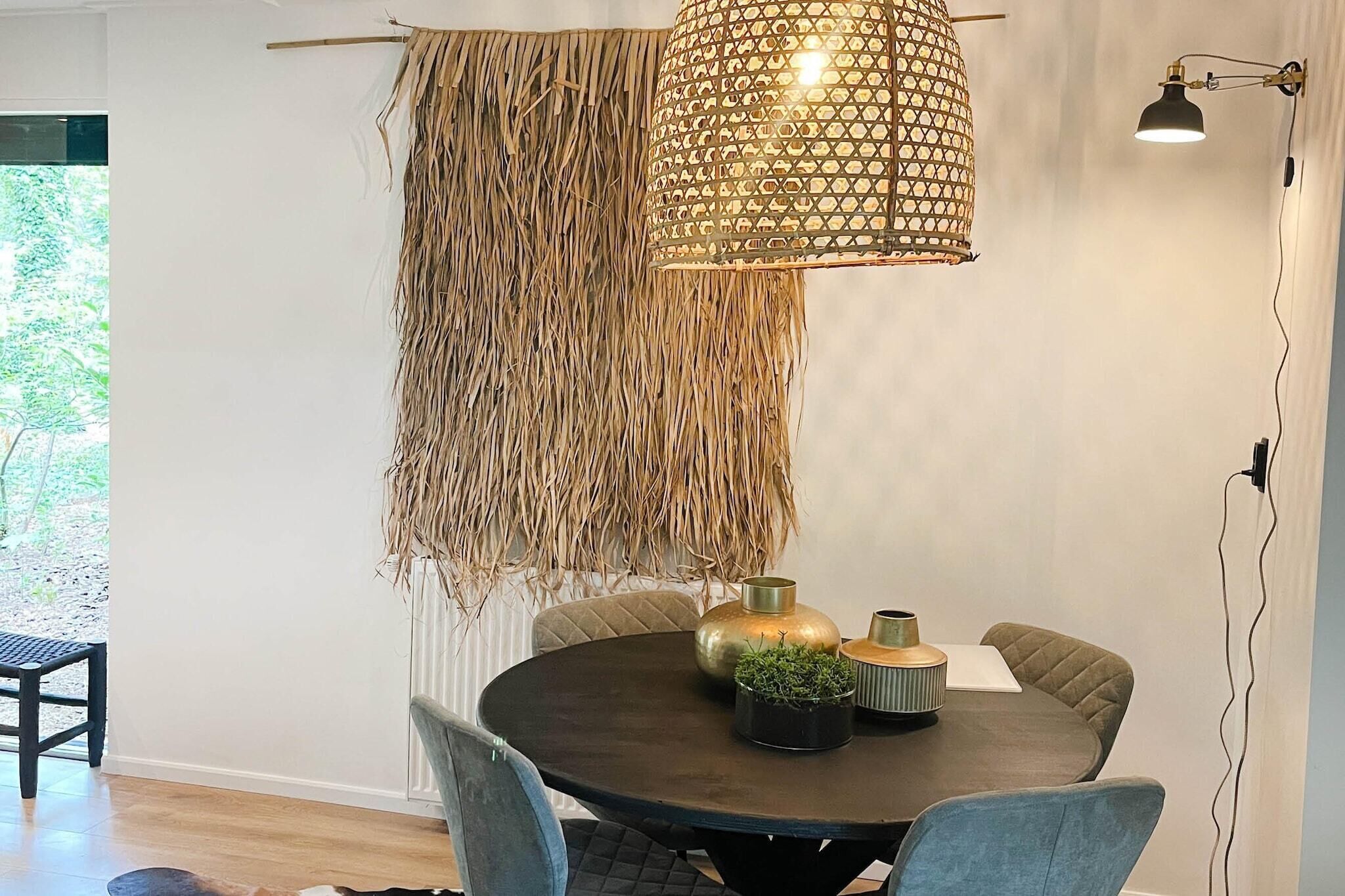 Un espace repas comprenant une table ronde, des chaises et un luminaire suspendu.