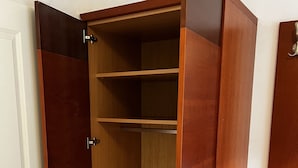Une armoire en bois avec plusieurs étagères et un petit banc.