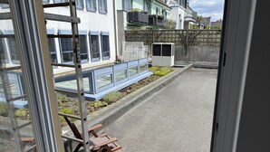 Une rue résidentielle bordée de maisons modernes, avec un banc bleu et une échelle en métal.