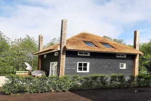 Ein Haus mit geneigtem Dach, einer Holztür und einem Fenster.