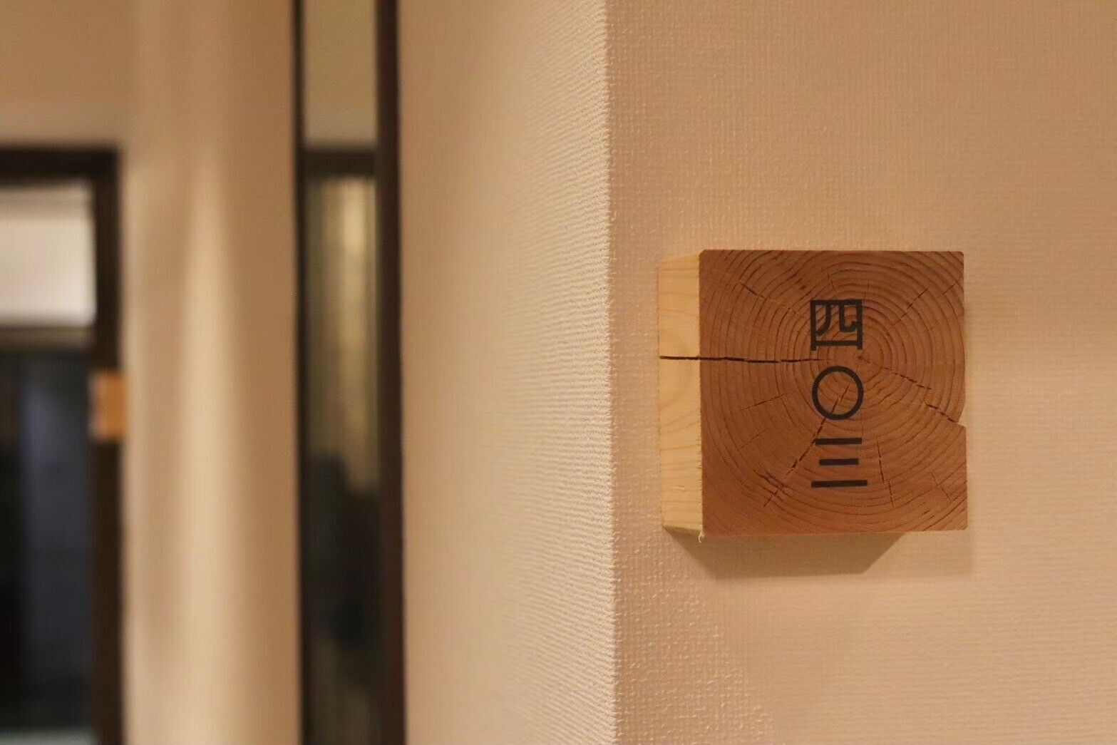 A wooden plaque with a design on a wall.