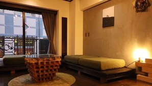 Una sala moderna con una mesa de centro de vidrio, un sofá y una cama.