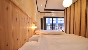 Habitación de hotel con dos camas, paneles de madera en las paredes, un balcón con vistas y un equipo de aire acondicionado.