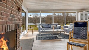 A modern living room with a brick fireplace, a sofa set, a coffee table, and a stone fireplace surround.