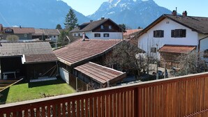 A residential area with houses, a wooden deck, and a mountain backdrop. - Holiday Home 'Hilde' with Mountain View, Private Terrace and Wi-Fi (Schwangau)