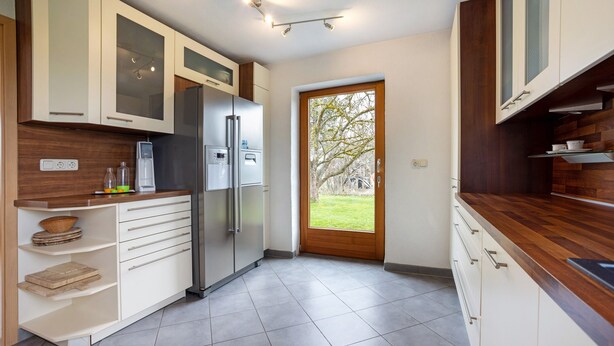 A modern kitchen with white cabinets, a stainless steel refrigerator, and a wooden countertop. - Holiday Home 'Hilde' with Mountain View, Private Terrace and Wi-Fi (Schwangau)
