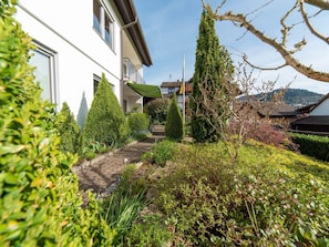 Een woonwijk met een pad naar een wit huis met balkon.