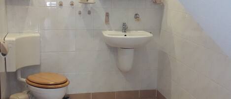 Un baño con inodoro, lavabo y bañera.